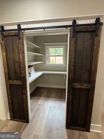 a view of walk in closet with wooden floor and closet