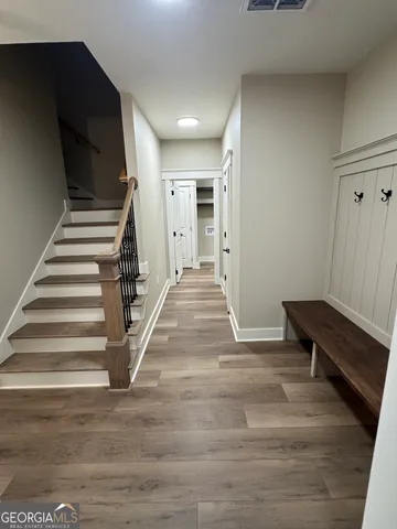 a view of entryway and hall with wooden floor
