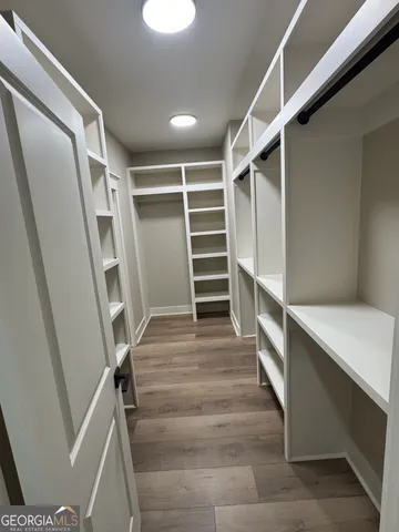 a view of walk in closet with empty racks