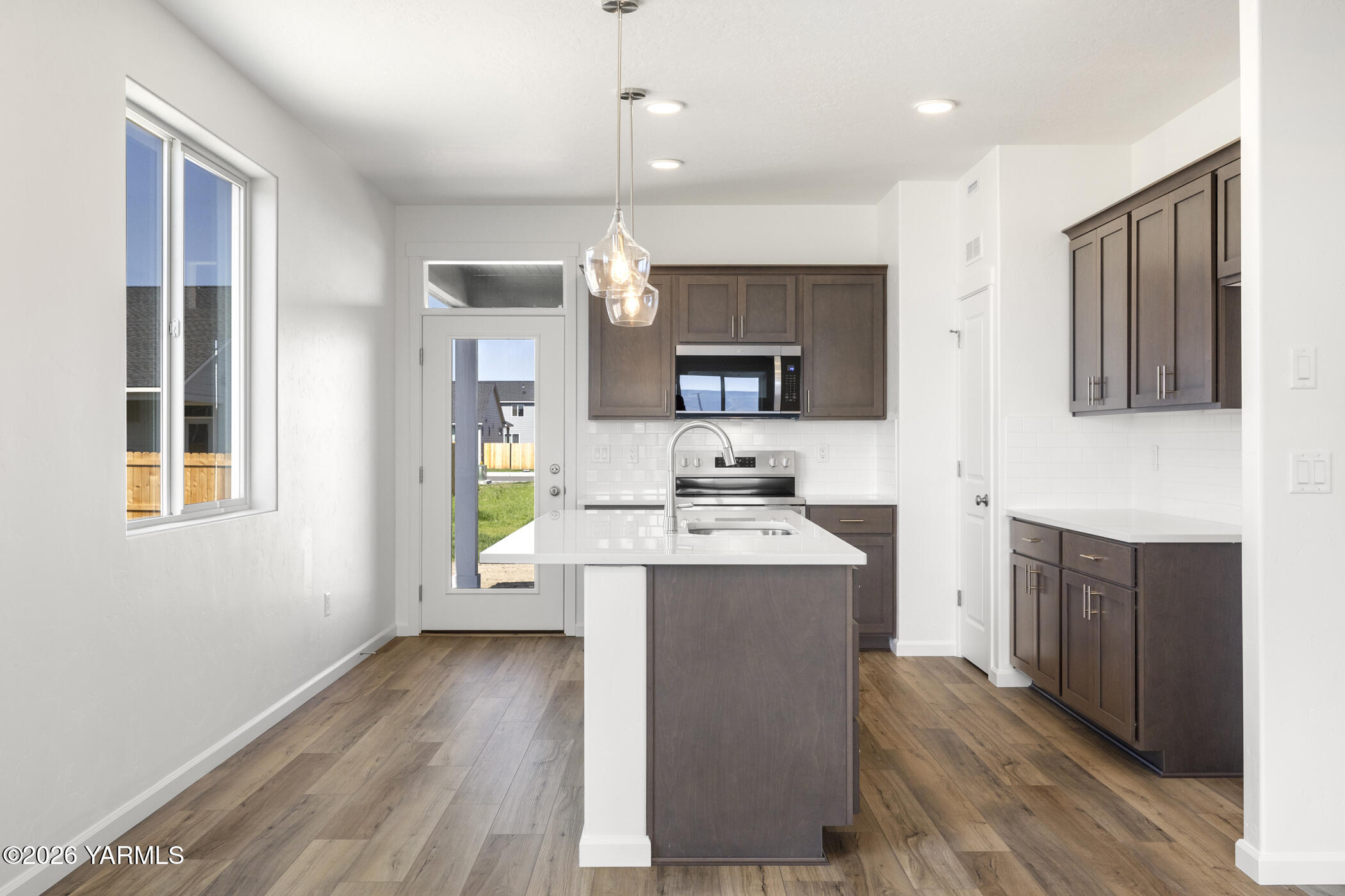 313 Amberly Avenue Grandview, WA 98930 - Photo 2 of 18 a kitchen with kitchen island granite countertop a sink appliances cabinets and a counter top space