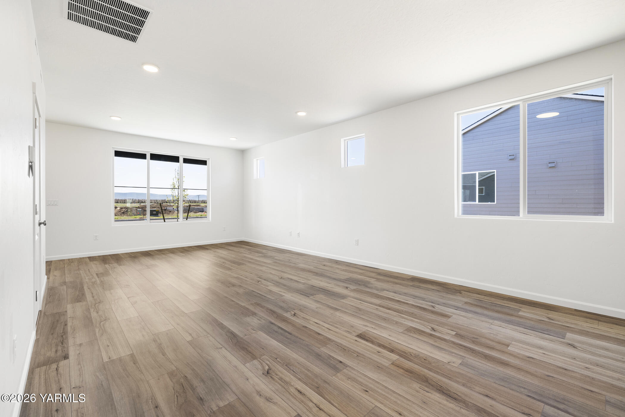 313 Amberly Avenue Grandview, WA 98930 - Photo 3 of 18 wooden floor in an empty room with a window