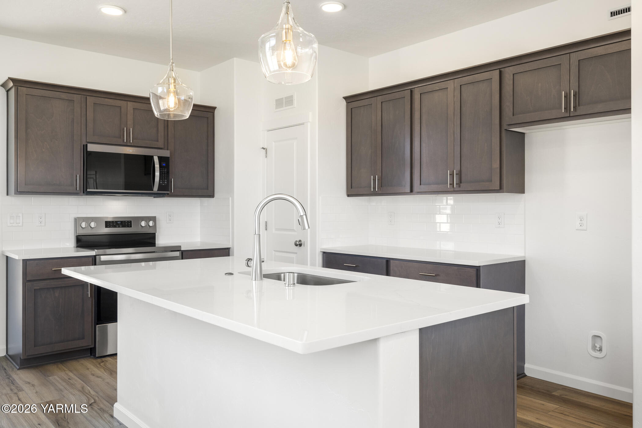 313 Amberly Avenue Grandview, WA 98930 - Photo 8 of 18 a kitchen with stainless steel appliances a stove a sink a microwave and wooden cabinets