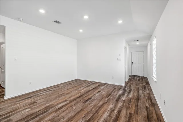 a view of a room with wooden floor and white walls