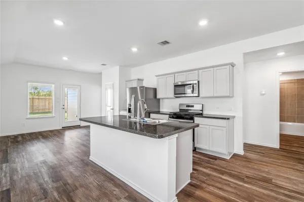 a kitchen with stainless steel appliances granite countertop a sink stove and refrigerator