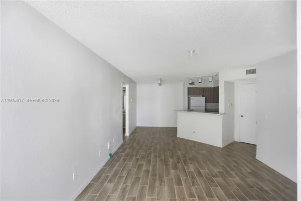 a view of a kitchen with wooden floor and electronic appliances