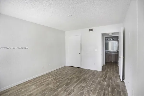 a view of a big room with wooden floor and a bathroom