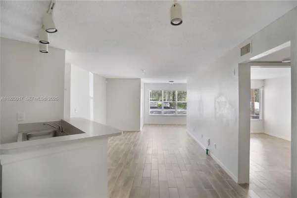 a view of hallway with a window and wooden floor