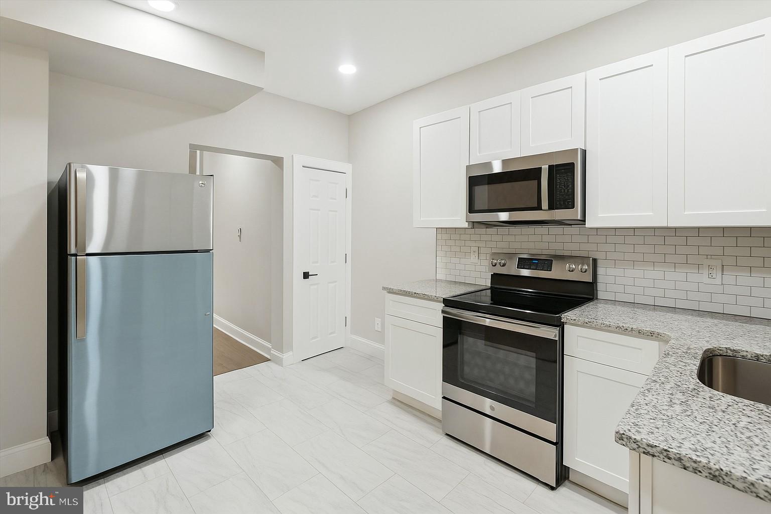 3047 Fontain Street Philadelphia, PA 19121 - Photo 2 of 15 a kitchen with stainless steel appliances granite countertop a refrigerator stove and microwave