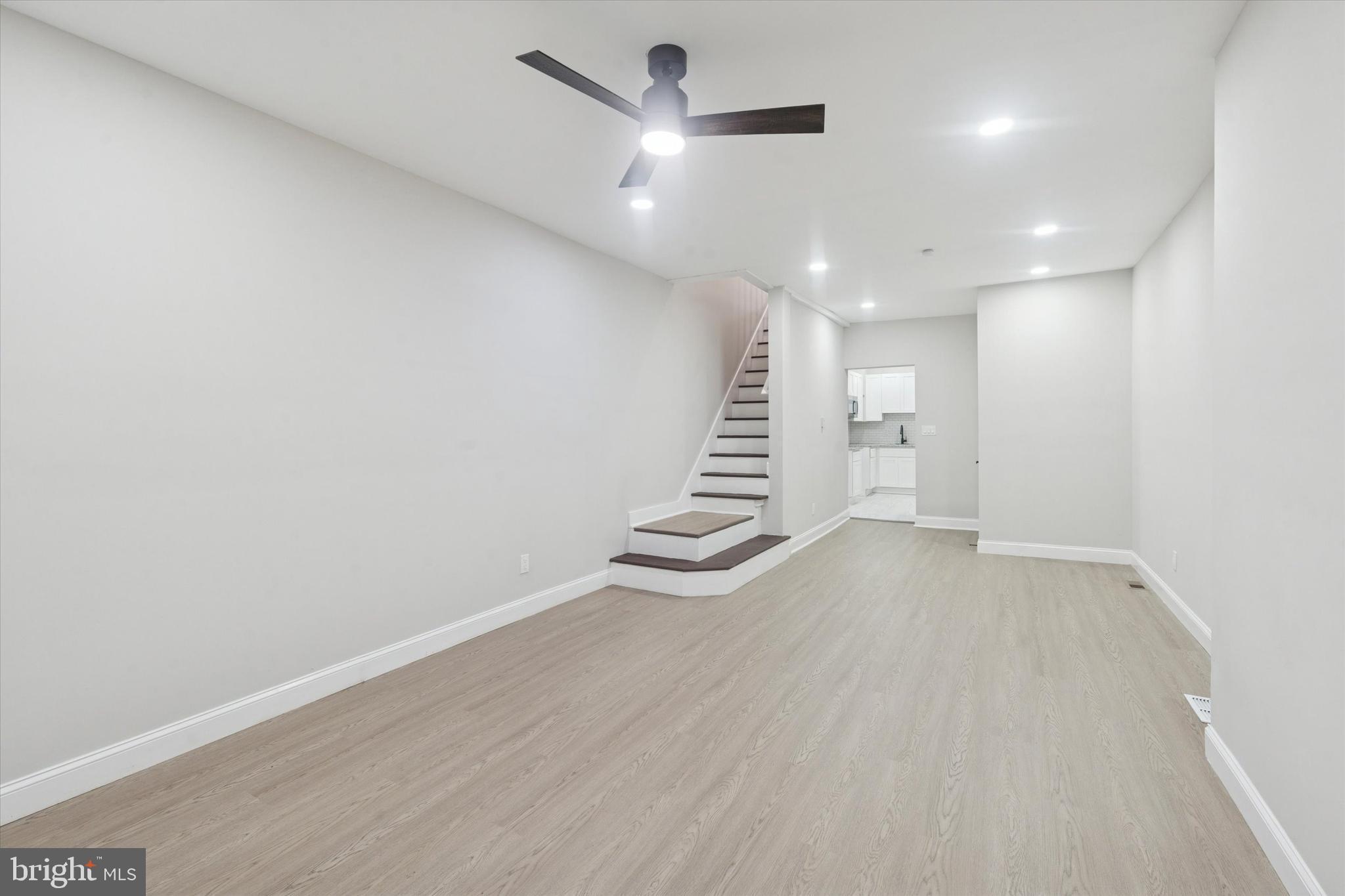 3047 Fontain Street Philadelphia, PA 19121 - Photo 4 of 15 an empty room with wooden floor a ceiling fan and windows