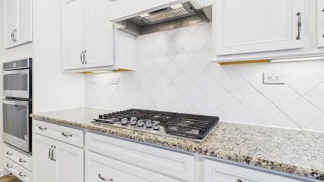 a large kitchen with kitchen island a stove a sink a dining table and chairs with wooden floor