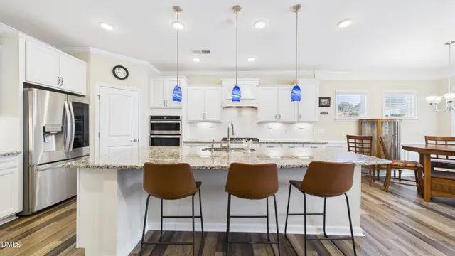 a kitchen with white cabinets and refrigerator