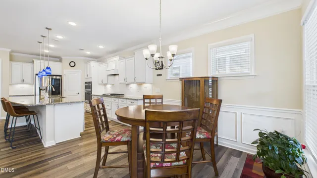 a kitchen with stainless steel appliances kitchen island granite countertop a table and chairs in it
