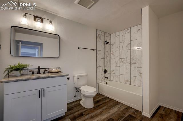7790 Julynn Road Colorado Springs, CO 80919 - Photo 44 of 50 Spacious Basement Full Bathroom with LVP floor, vanity with quartz countertops, framed mirror, and tiled tub/shower.