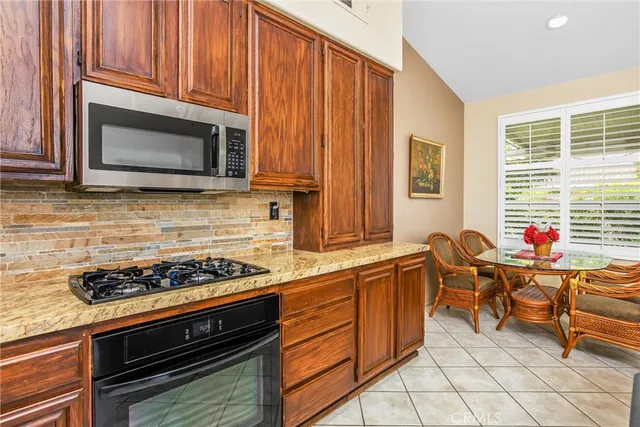 a kitchen with stainless steel appliances a stove a sink cabinets and a window