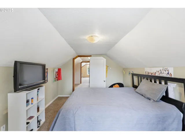 a bedroom with a bed and a flat screen tv