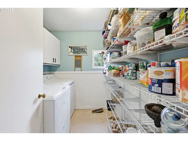 a utility room with stainless steel appliances kitchen island a table and chairs in it