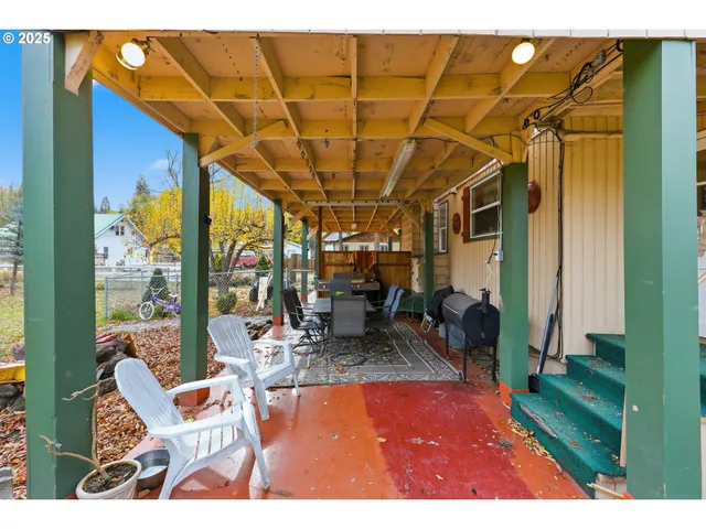 a view of two chairs in the balcony with wooden fence