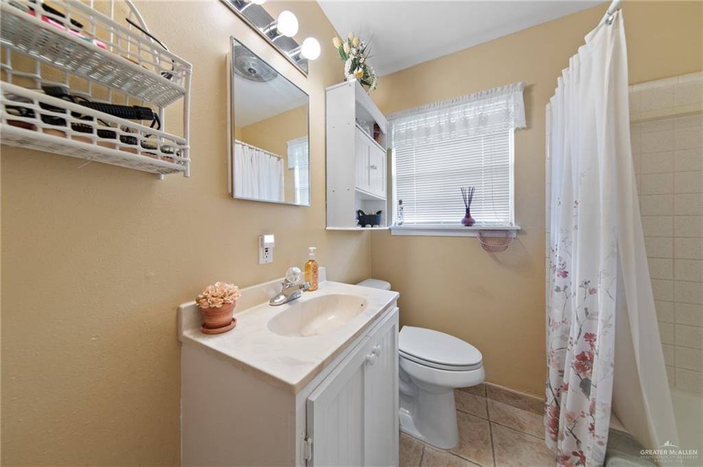 1012 West 3rd Street Weslaco, TX 78596 - Photo 17 of 27 a bathroom with a sink a toilet and a mirror