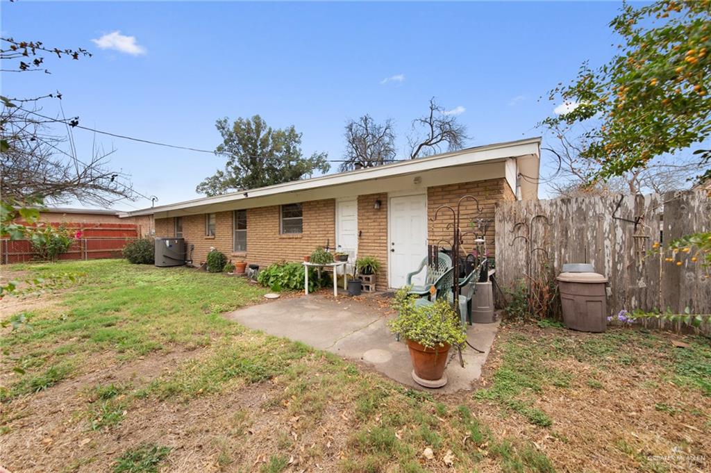 1012 West 3rd Street Weslaco, TX 78596 - Photo 22 of 27 a view of a patio with table and chairs potted plants and large tree