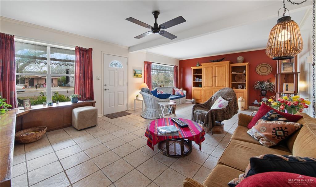 1012 West 3rd Street Weslaco, TX 78596 - Photo 5 of 27 a living room with furniture a chandelier and a floor to ceiling window