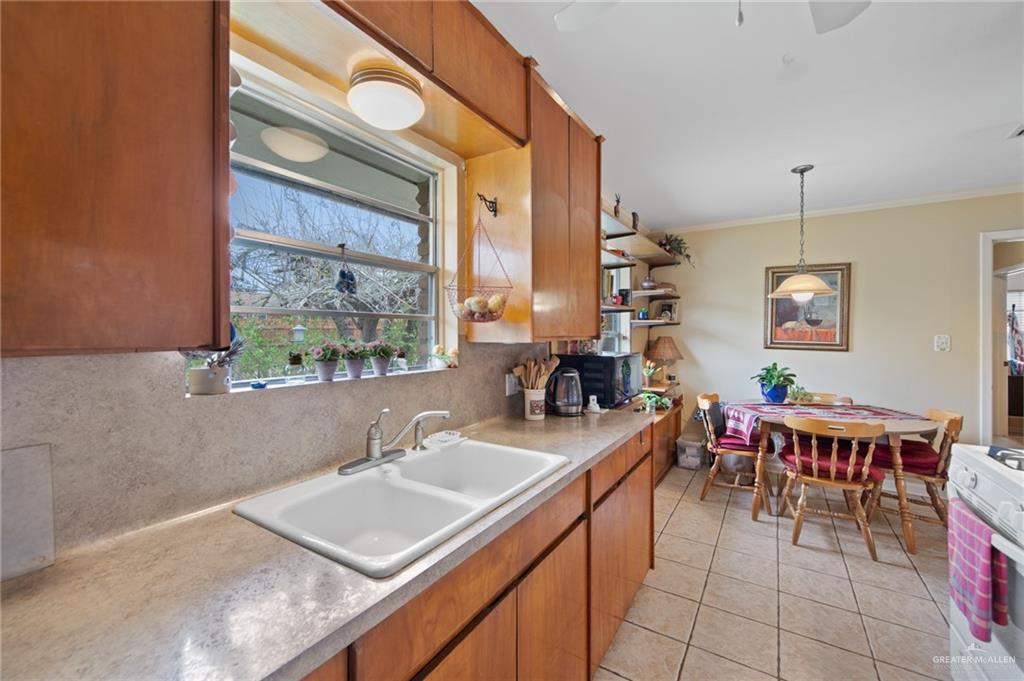1012 West 3rd Street Weslaco, TX 78596 - Photo 8 of 27 a kitchen with a sink a counter top space and living room view
