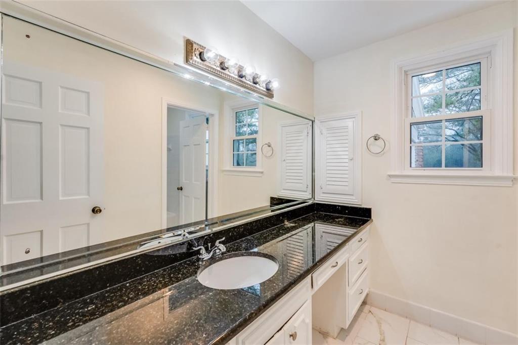 5550 Koweta Road South Fulton, GA 30349 - Photo 14 of 58 a bathroom with a granite countertop sink a large mirror and a window