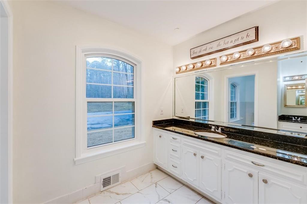 5550 Koweta Road South Fulton, GA 30349 - Photo 21 of 58 a bathroom with a granite countertop sink and a mirror