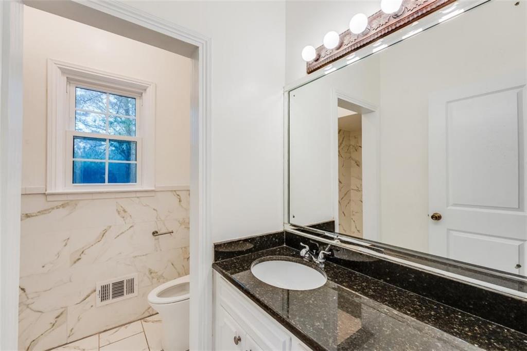 5550 Koweta Road South Fulton, GA 30349 - Photo 22 of 58 a bathroom with a granite countertop sink and a mirror