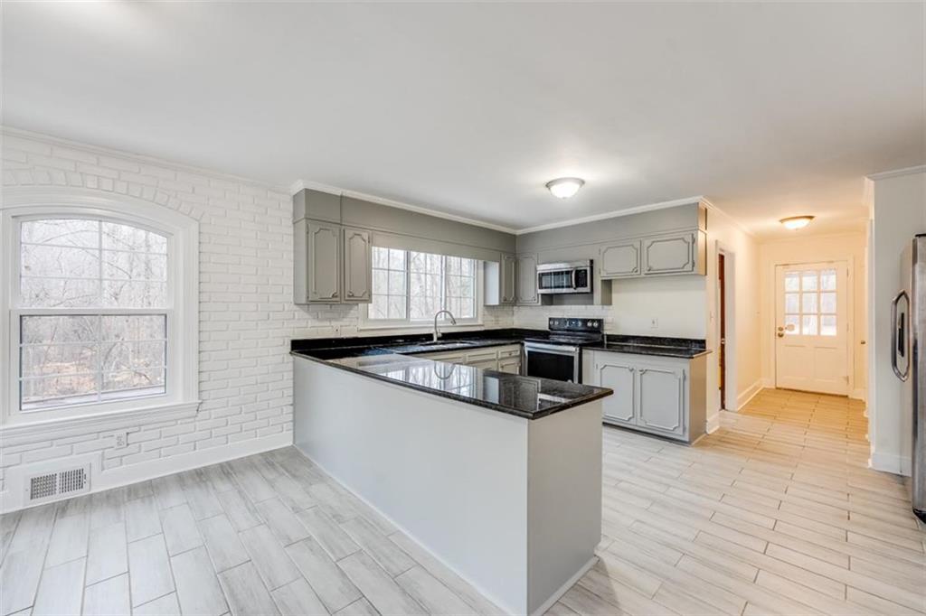 5550 Koweta Road South Fulton, GA 30349 - Photo 25 of 58 a kitchen with stainless steel appliances granite countertop a stove and a refrigerator
