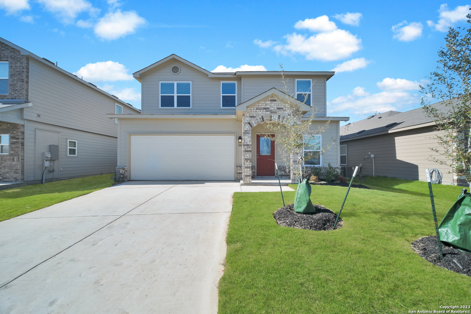a front view of a house with a yard and a fountain