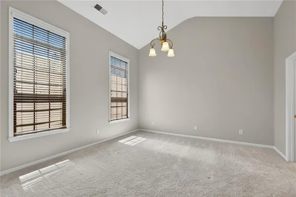 an empty room with windows and ceiling fan