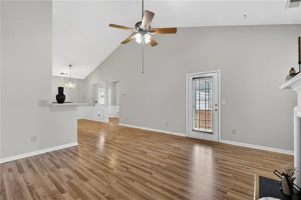 a view of empty room with wooden floor and fan