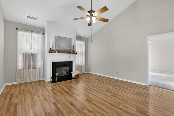 a view of empty room with fireplace and wooden floor