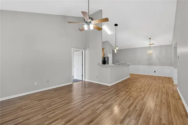 a view of a room with wooden floor and a ceiling fan