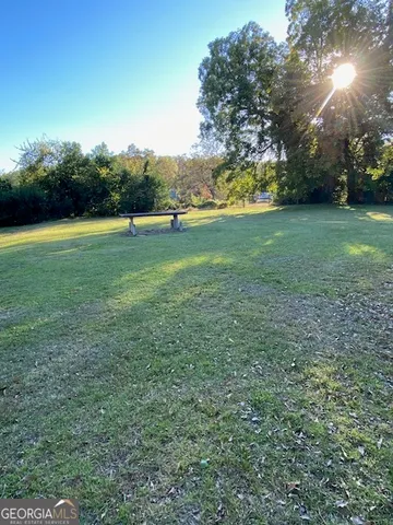 a view of outdoor space with green field and trees all around