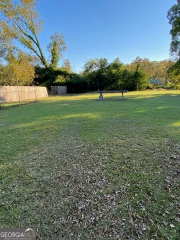 a view of a green field with trees in the background