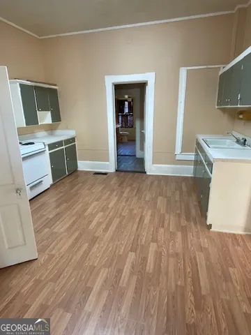 a view of a kitchen with wooden floor and electronic appliances
