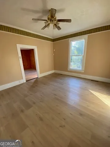 a view of empty room with wooden floor