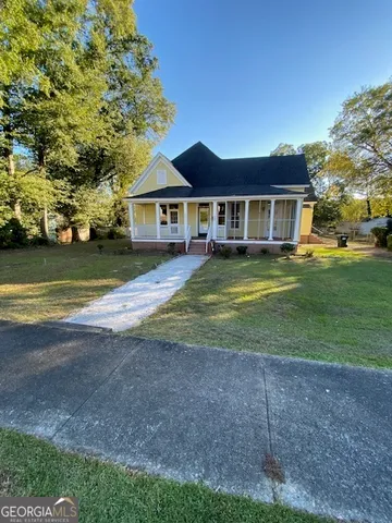 a view of a big house with a big yard and large trees