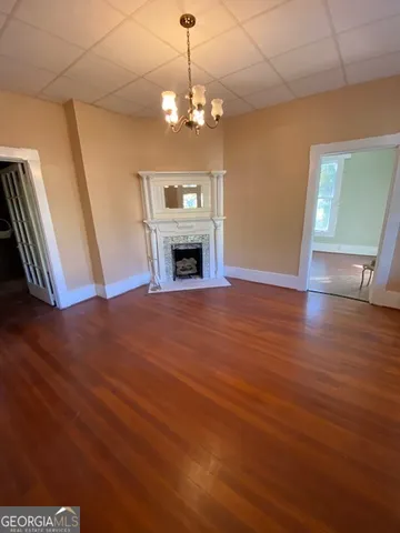 a view of a livingroom with wooden floor fireplace and staircase