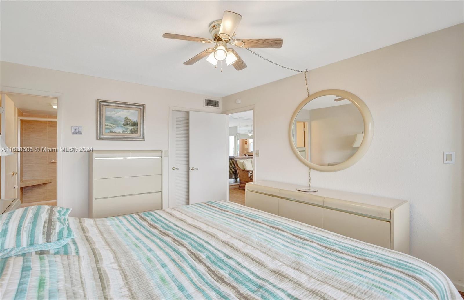 2611 North Riverside Drive, Unit 301 Pompano Beach, FL 33062 - Photo 12 of 31 a bedroom with a bed and a chandelier