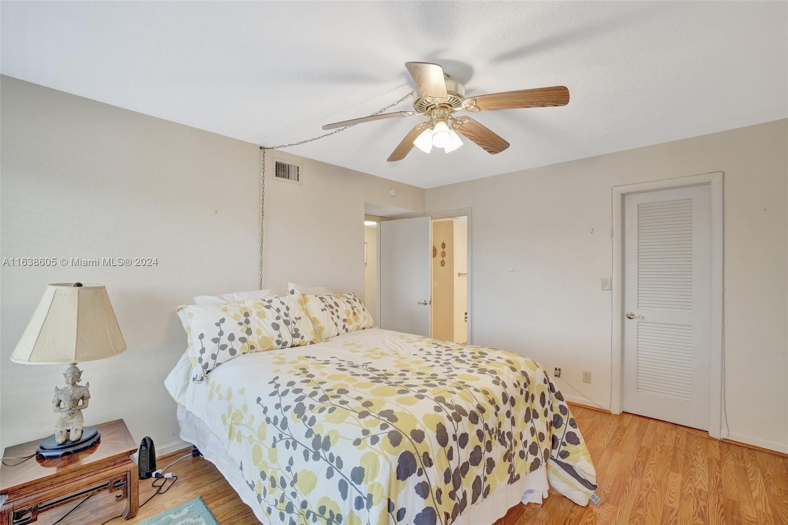 2611 North Riverside Drive, Unit 301 Pompano Beach, FL 33062 - Photo 15 of 31 a bedroom with a bed and wooden floor