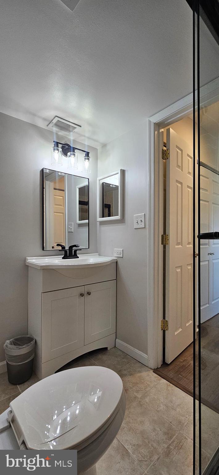 5831 Cove Landing Road, Unit 301 Burke, VA 22015 - Photo 19 of 33 a bathroom with a toilet a sink and mirror