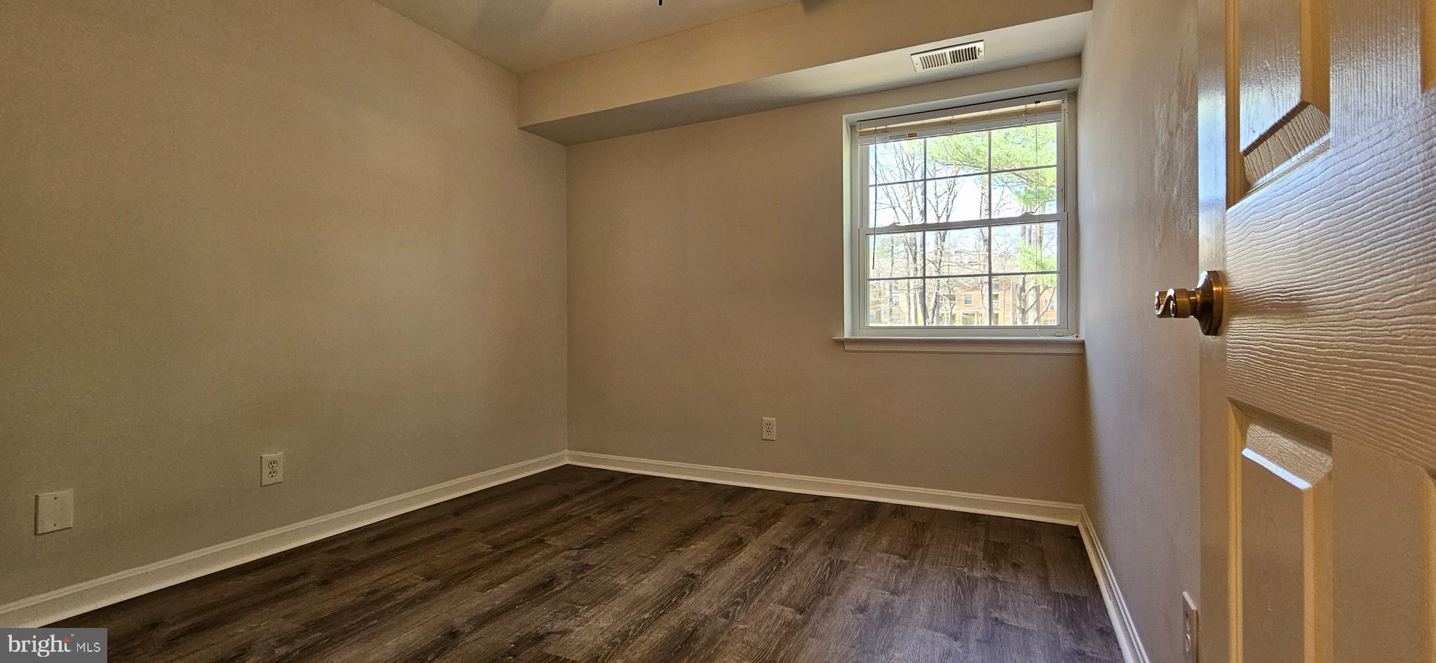 5831 Cove Landing Road, Unit 301 Burke, VA 22015 - Photo 20 of 33 an empty room with wooden floor and windows