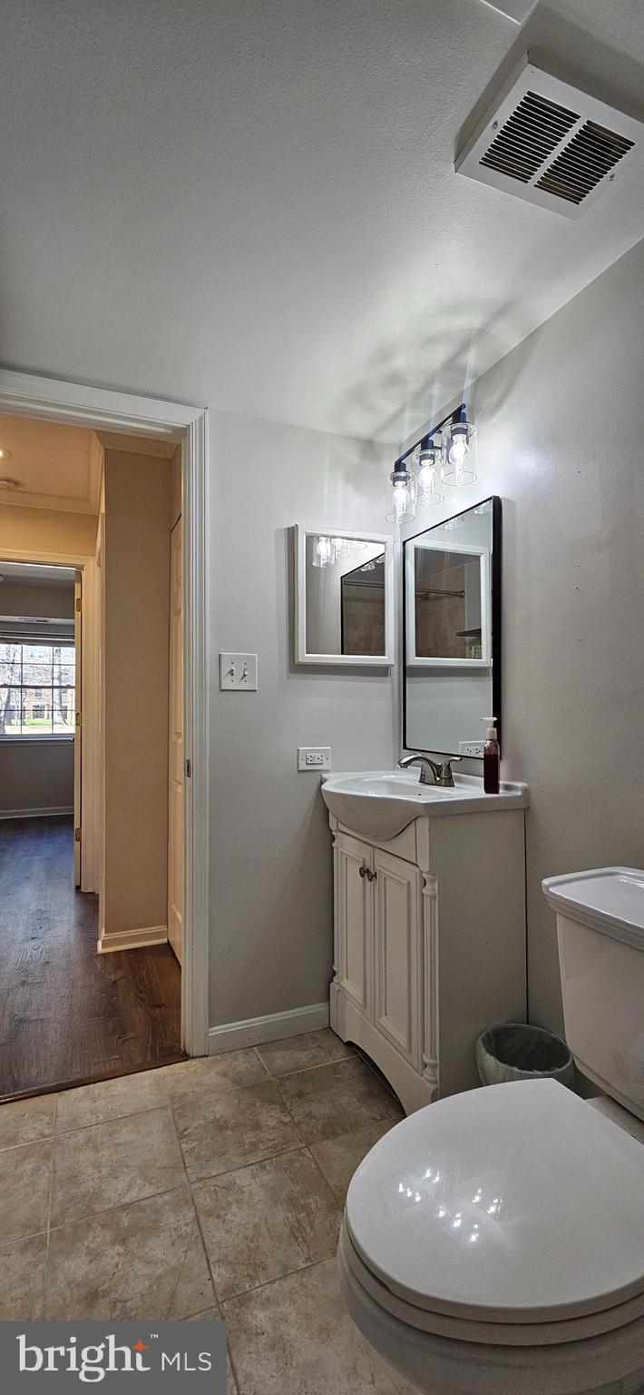 5831 Cove Landing Road, Unit 301 Burke, VA 22015 - Photo 25 of 33 a bathroom with a toilet a sink and mirror