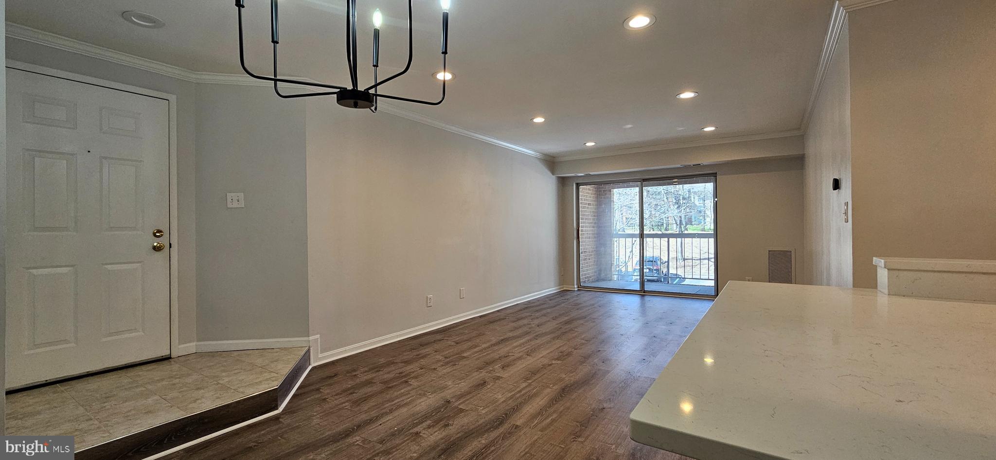 5831 Cove Landing Road, Unit 301 Burke, VA 22015 - Photo 5 of 33 a view of an empty room with wooden floor and a window