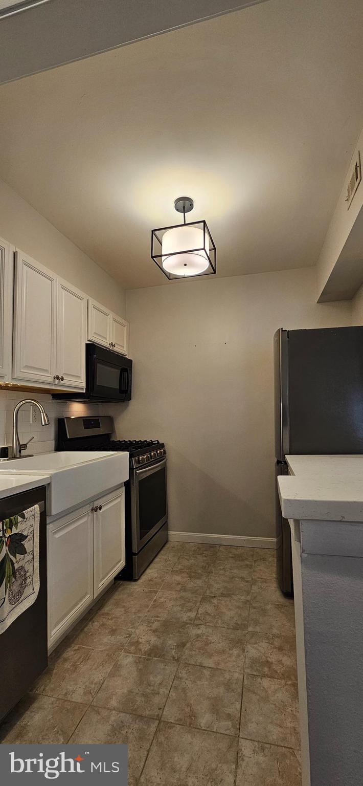 5831 Cove Landing Road, Unit 301 Burke, VA 22015 - Photo 9 of 33 a kitchen with a refrigerator and a stove top oven