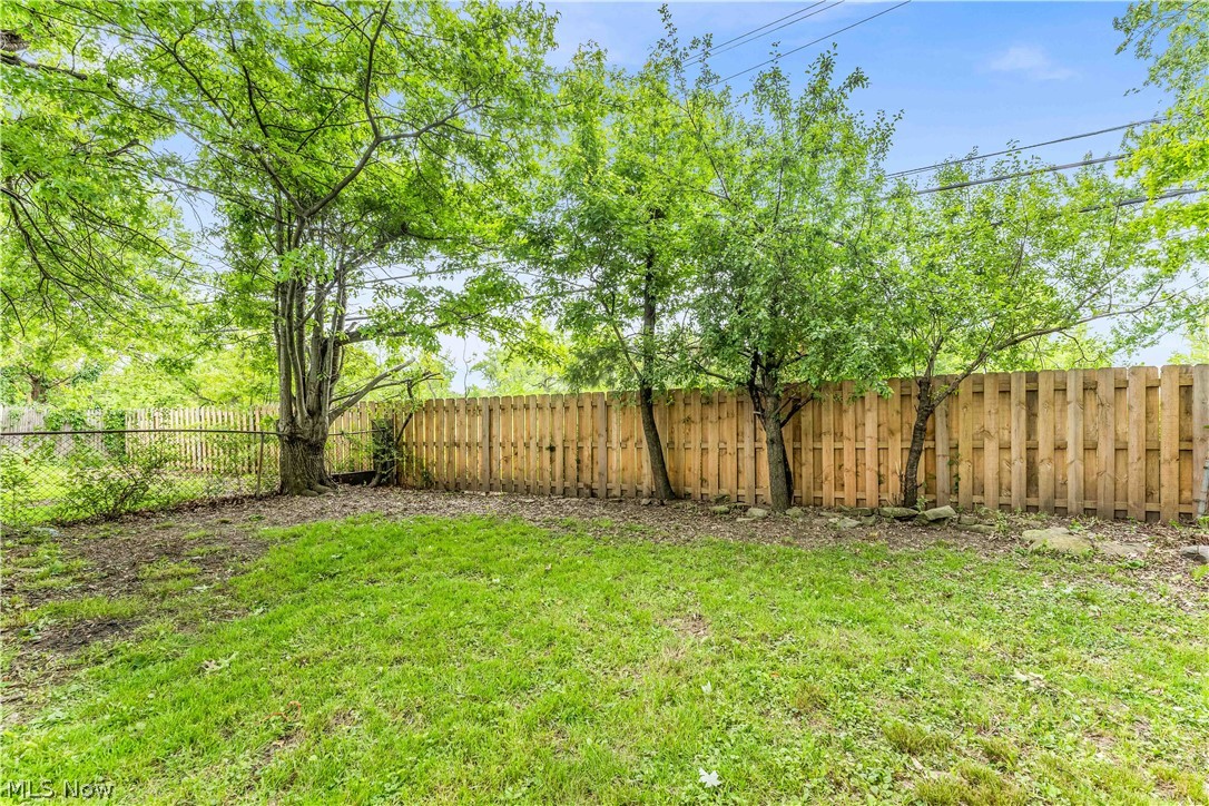 18517 Homeway Road Cleveland, OH 44135 - Photo 27 of 29 Expansive green space featuring a wood privacy fence, partial chain-link fencing, and mature trees providing natural shade