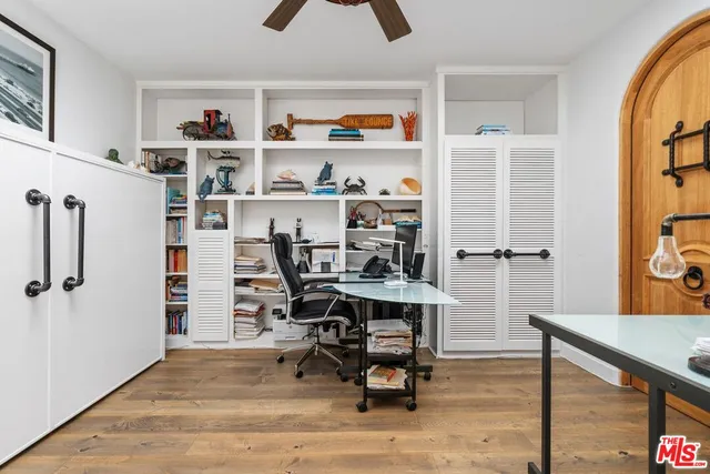 a view of a workspace with furniture and a window