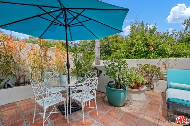 a view of a patio with chairs and potted plants